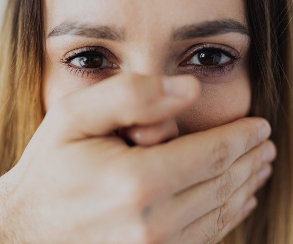 woman covering her face with her hand