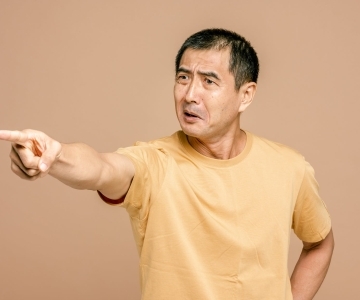 man in yellow crew neck t shirt pointing a finger