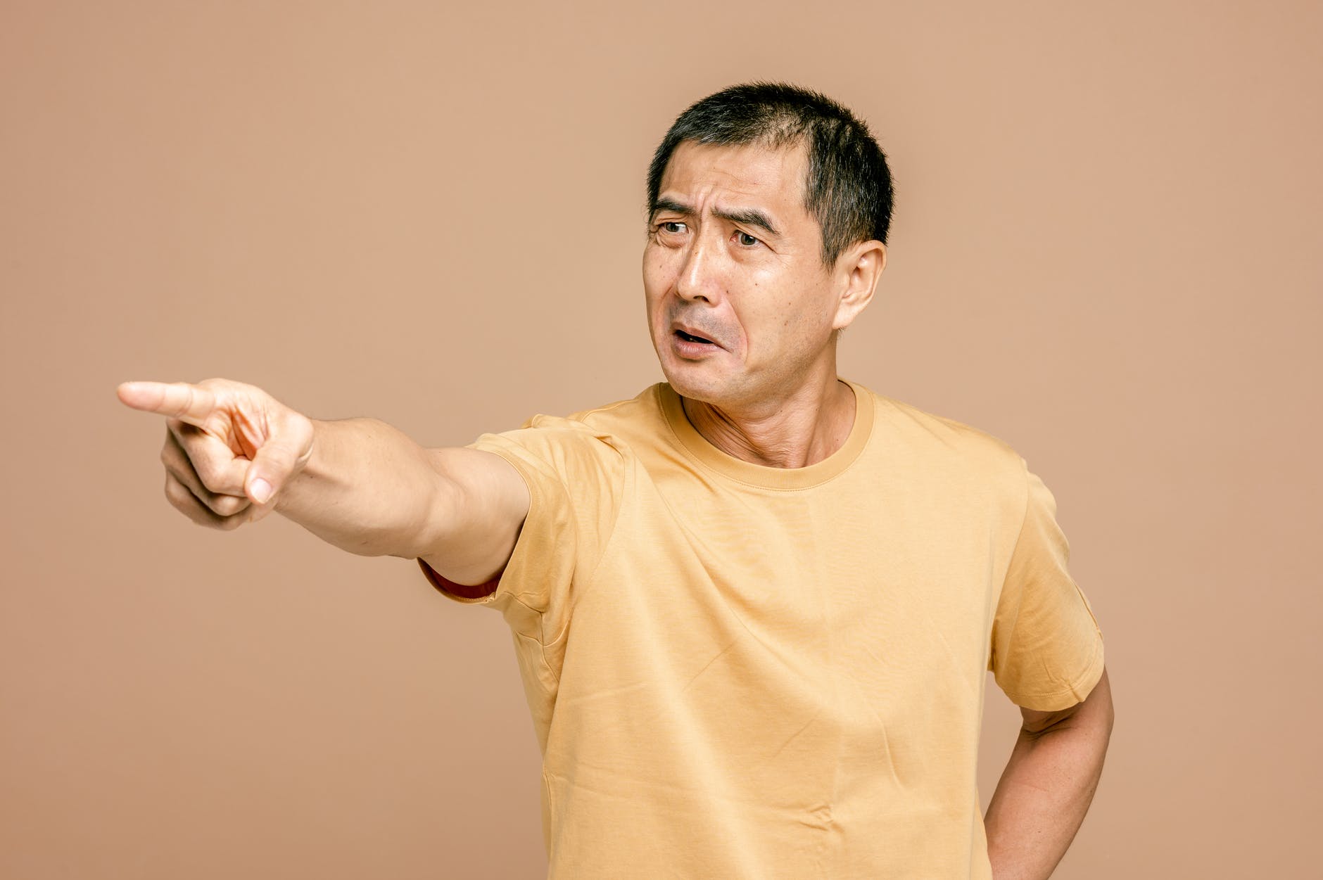 man in yellow crew neck t shirt pointing a finger